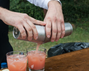 A bartender creating a pink drink