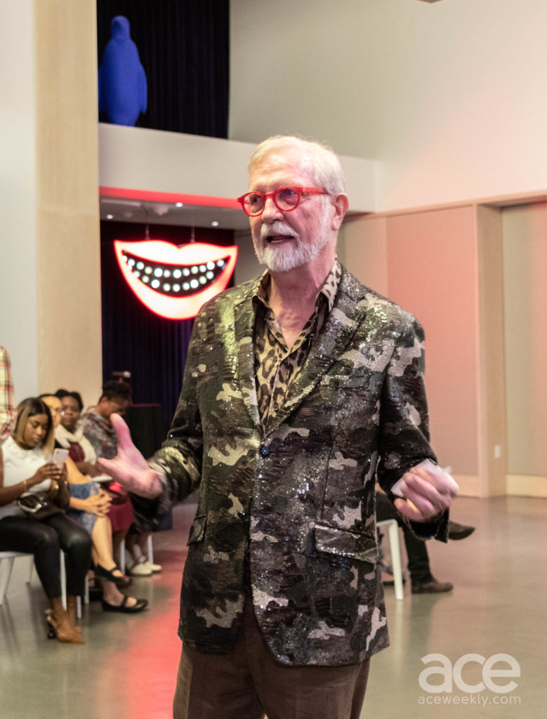 a man in a camoflauge sparkly jacket talking to an audience