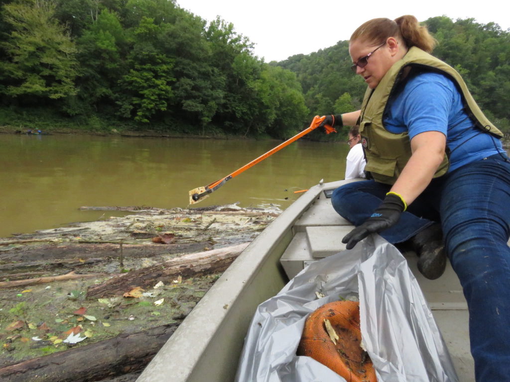 Kentucky River Clean Sweep: a woman on a boat cleaning a body of water