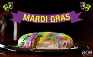 mardi gras: king cake with purple, green, and yellow with signs that say mardi gras