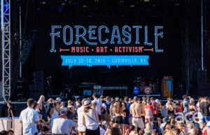 A stage with people in front and a sign that says Forecastle