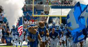 Kentucky: mascots, cheerleaders, and football players running onto a field