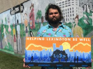 Community: a man holding a mural in front of a wall